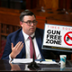 Robert Barrows of the New York City Police Department holds up a “gun-free zone” sign during a City Council meeting Tuesday, Aug. 30, 2022
